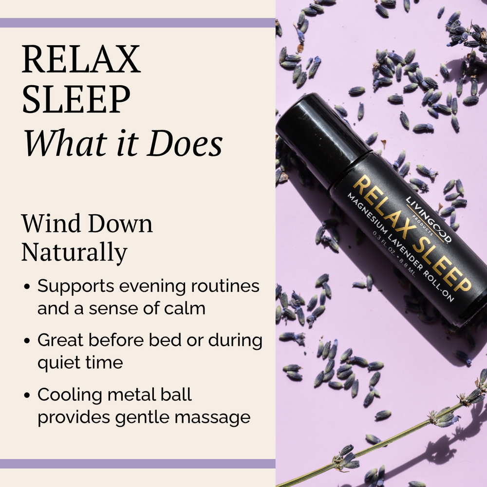 A small amber glass roller bottle with a black cap standing beside it on a light marble surface. The bottle is labeled 'LIVINGOOD RELAX SLEEP MAGNESIUM & LAVENDER ROLL ON'.