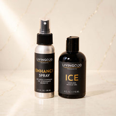 Two Living Good Products bottles on a light marble surface: a silver spray bottle labeled Enhance Spray and a black bottle labeled Ice Cooling Muscle Gel.