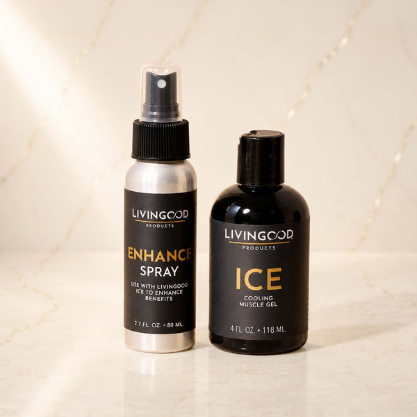 Two Living Good Products bottles on a light marble surface: a silver spray bottle labeled Enhance Spray and a black bottle labeled Ice Cooling Muscle Gel.