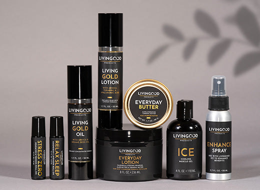 A collection of Livingood products arranged on a neutral gray background with soft leaf shadows.