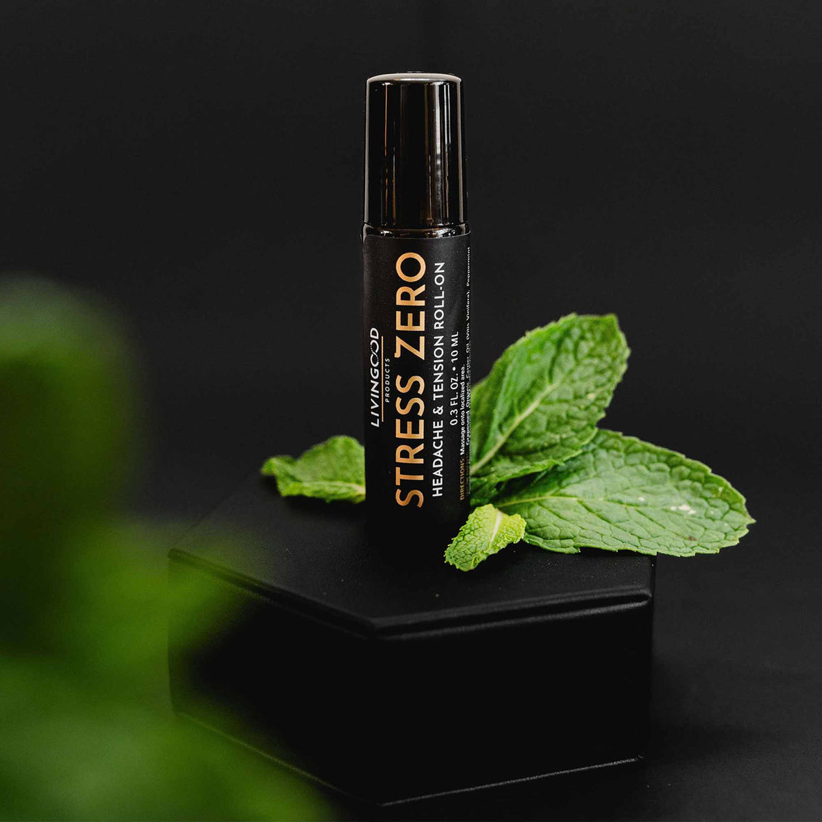 Livingood Stress Zero roll on on a black background with a peppermint leaf