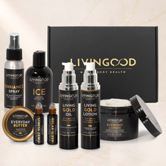 A Livinggood body care gift set arranged in front of a black gift box on a light marble background. The set includes an Everyday Butter jar, an Enhance Spray bottle, an Ice bottle, a Living Gold Oil bottle, a Living Gold Lotion bottle, a Stress & Relax roller bottle, and a jar of Everyday Lotion with its lid leaning beside it.
